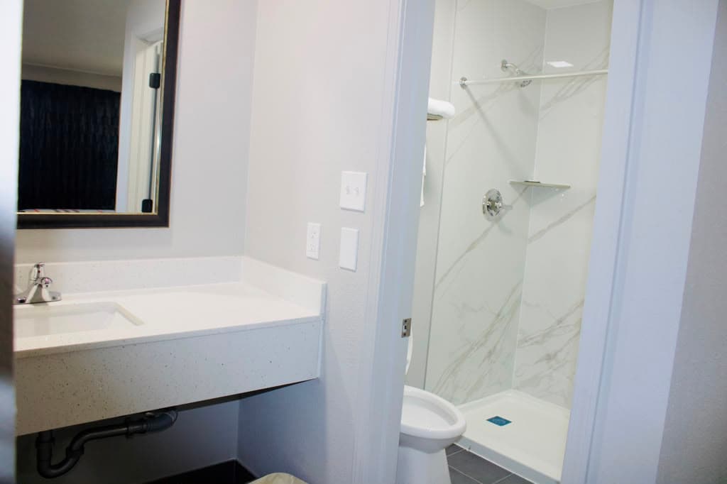 Bathroom with vanity, toilet, and marble-look shower