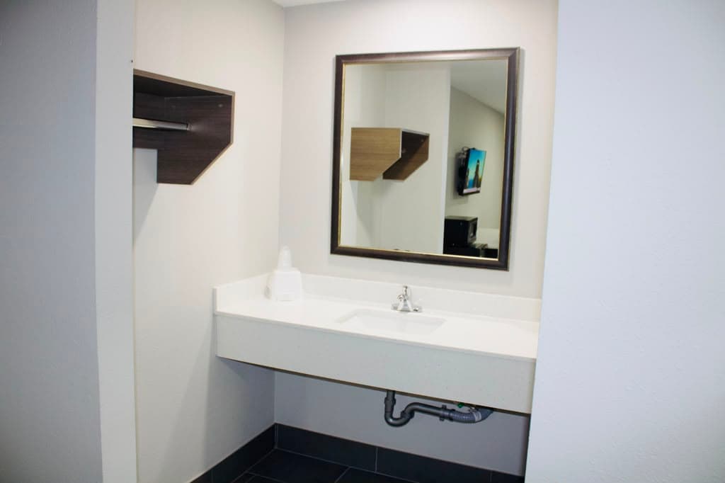 Vanity with framed mirror reflecting the suite