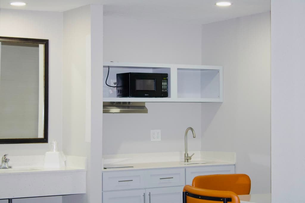Kitchenette with microwave shelf, range hood, and seating