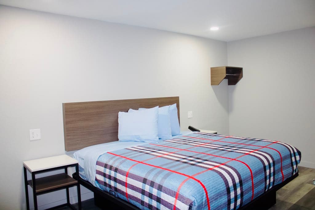 Guest suite with a plush bed, wood headboard, and bedside table