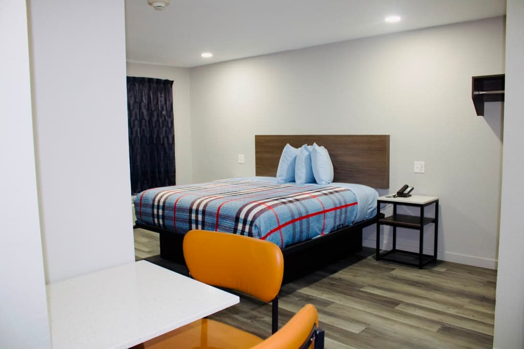 Studio suite with a queen bed, dining table, and closet shelf
