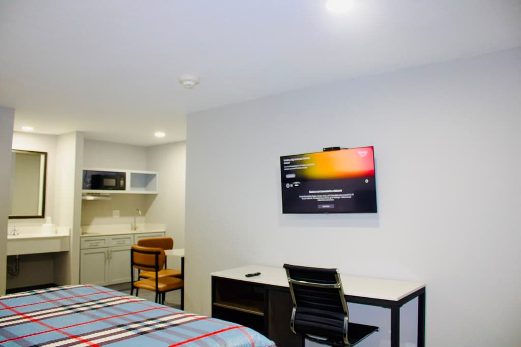 Studio suite with flat-screen TV, work desk, and kitchenette