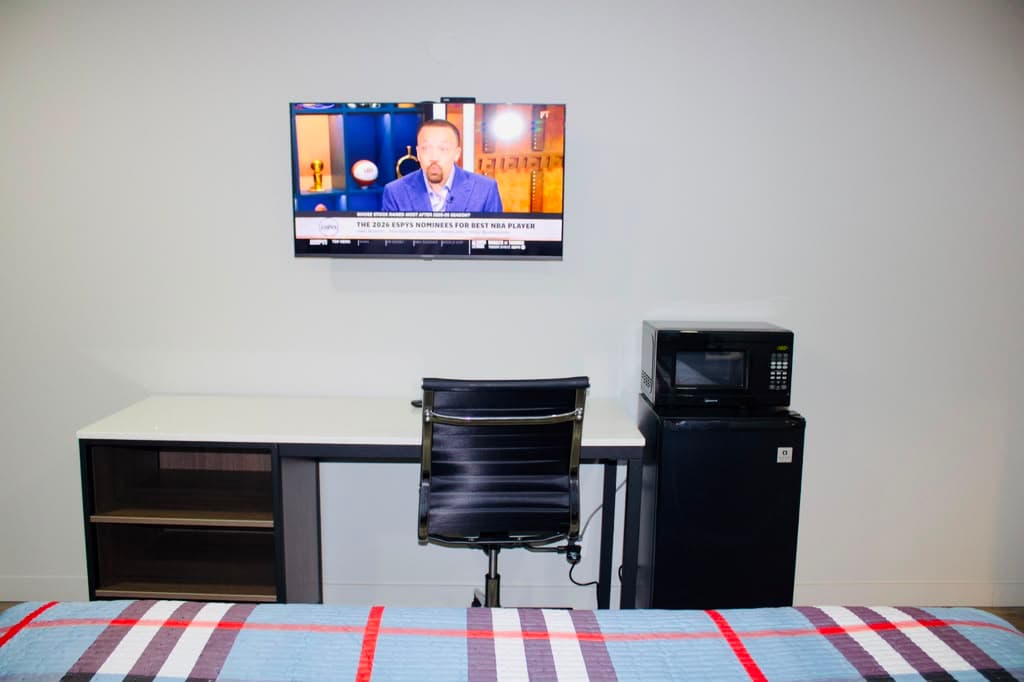 Work desk with office chair, TV, microwave, and mini-fridge